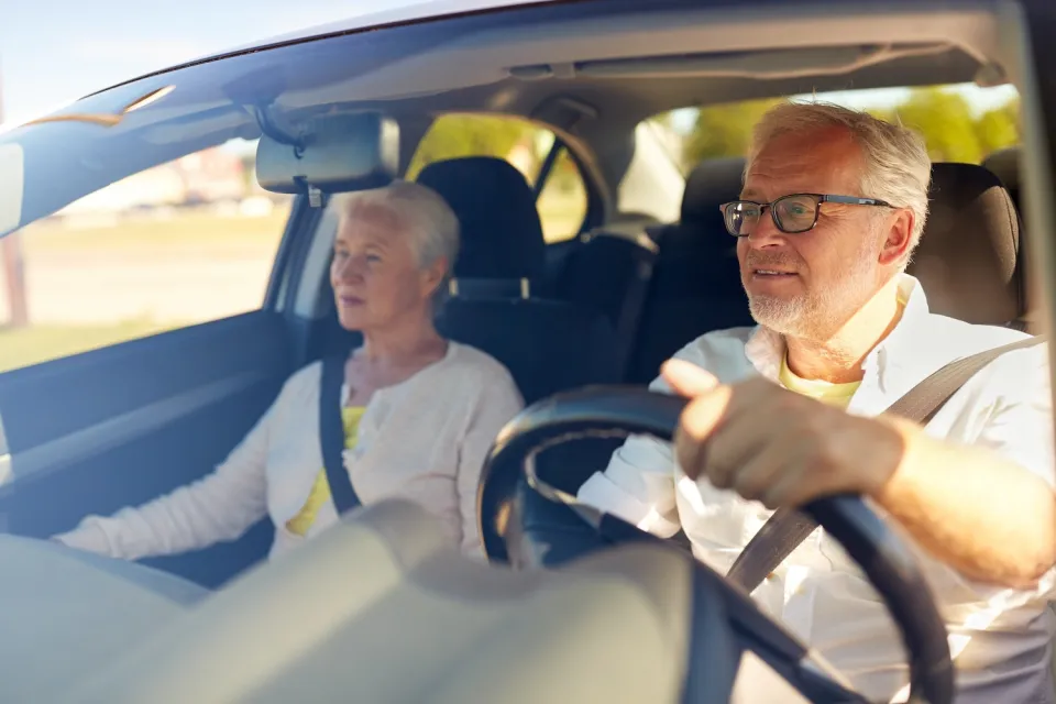 Senior couple driving car.